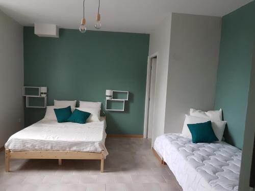 Duas camas num quarto com paredes verdes e brancas em La Capèra em Lachapelle