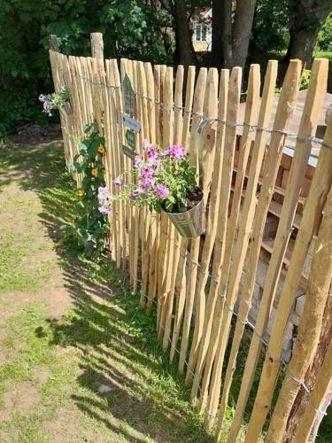 a wooden fence with a pot of flowers on it at Tiny House am Elsbach in der bayerischen Rhön. in Oberelsbach