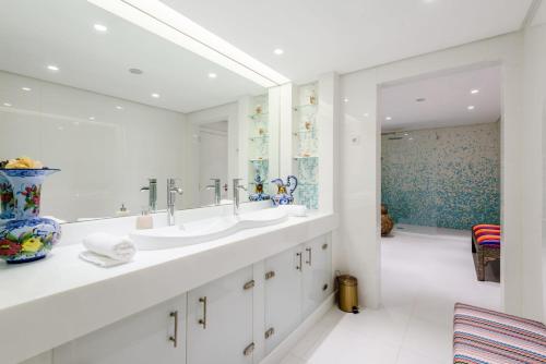 a bathroom with two sinks and a large mirror at Marina Real - Sea View by HD PROPERTIES in Vilamoura