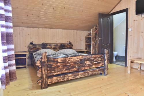 a bedroom with a large wooden bed in a room at Газдівська Хижа in Pilipets