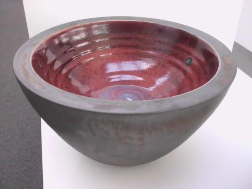 a red bowl sitting on top of a table at Cabbage Tree Chalet in Parapara 