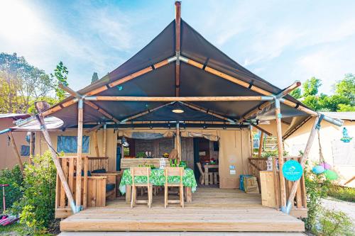a tent with a table and chairs on a wooden deck at Camping Village Riva Blu in Padenghe sul Garda