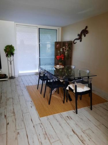 une salle à manger avec une table et des chaises en verre dans l'établissement Dune, à La Teste-de-Buch