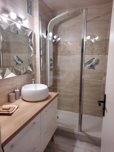 a bathroom with a sink and a glass shower at Dune in La Teste-de-Buch