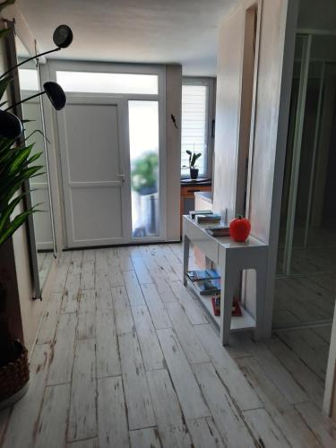 Cette chambre dispose d'une porte et d'une table avec une pomme. dans l'établissement Dune, à La Teste-de-Buch