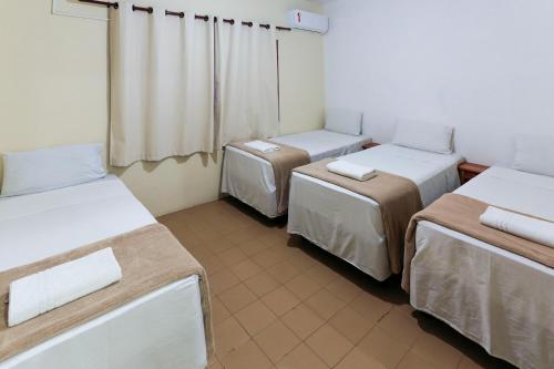 a room with three beds in a room at Indaiá Praia Hotel in Bertioga