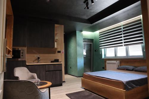 a bedroom with a bed and a kitchen with a sink at Something Different in Nikšić
