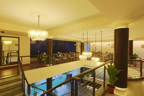 um átrio do hotel com uma piscina e um restaurante em Hotel Arch Plaza - Near Delhi Airport em Nova Deli