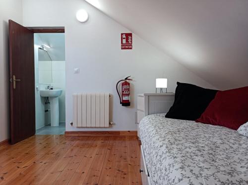 a bedroom with a bed and a bathroom with a sink at Fantástico apartamento en las playas de Suances in Suances