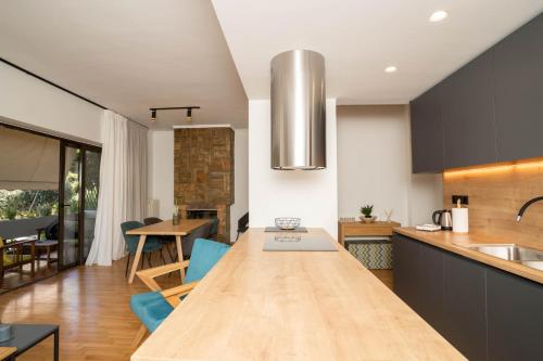 kuchnia z długim drewnianym stołem w pokoju w obiekcie AthensBlues Glyfada Premium w Atenach