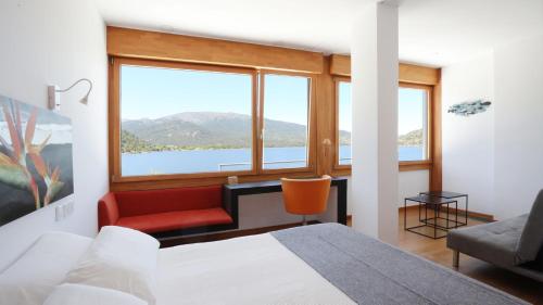 a bedroom with a bed and a chair and a window at Posada del Agua in El Barraco