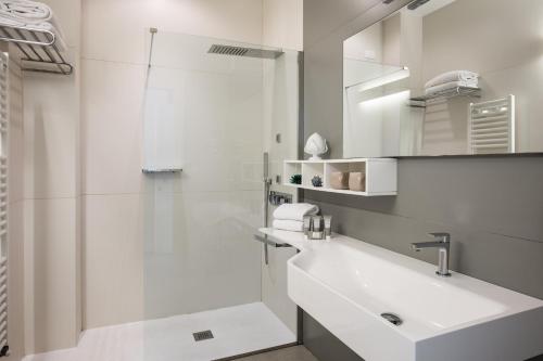 a white bathroom with a sink and a shower at Giardino Dei Pini - Boutique Hotel in Alliste