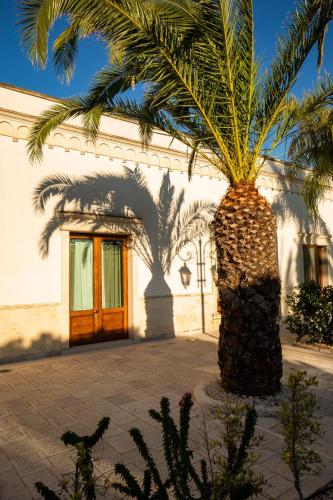 a palm tree in front of a building at Giardino Dei Pini - Boutique Hotel in Alliste