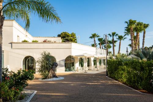 a building with a palm tree in front of it at Giardino Dei Pini - Boutique Hotel in Alliste