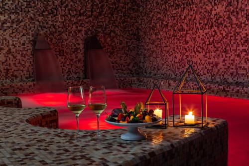 a table with two glasses of wine and a plate of fruit at Giardino Dei Pini - Boutique Hotel in Alliste