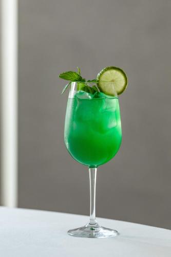 a green drink in a glass with a lime at Giardino Dei Pini - Boutique Hotel in Alliste