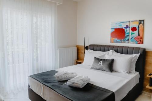 a bedroom with a bed with two towels on it at ALEXANDRA Boutique Residence Seaside in Alexandroupoli