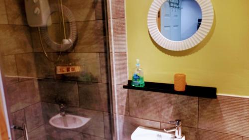y baño con ducha, lavabo y espejo. en Stunning 1-Bed Cabin in Bromley with hot tub, en Bromley
