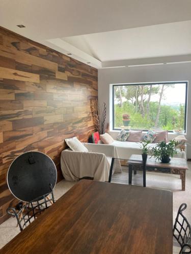 a living room with a wooden accent wall at Villa de charme avec piscine et jacuzzi dans cadre exceptionnel proche Marseille in Les-Pennes-Mirabeau