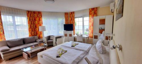 Hotel Waterkant في ساسنيتز: غرفة معيشة بها أريكة وغرفة معيشة بها