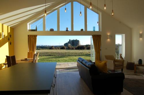 a living room with a table and a large window at Beautiful, Modern Villa 5 mins walk from the Stunning Bay at Trearddur in Holyhead