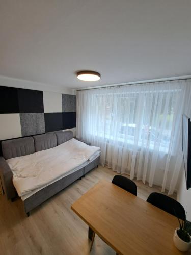 Schlafzimmer mit einem Bett und einem Tisch mit Stühlen in der Unterkunft New cosy Karklu Apartment in Klaipeda in Klaipėda