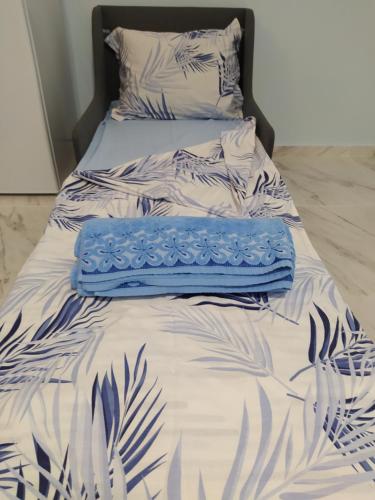 ein Bett mit einer blauen und weißen Bettdecke darauf in der Unterkunft Апартамент Blue apartment, гр. Китен in Kiten