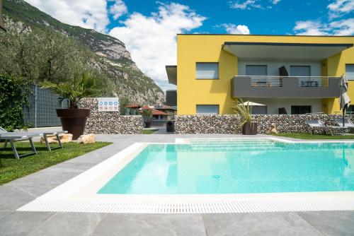 a villa with a swimming pool in front of a house at Ca' de L'Olif - Holiday Clima Apartments in Dro