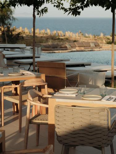 a table and chairs with a view of the ocean at NOS Hotel & Villas in Sifnos