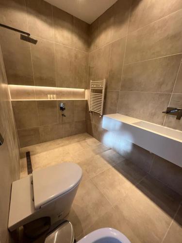 a bathroom with a toilet and a bath tub at Coquena · Casita con Parrilla y Viñedo in Purmamarca