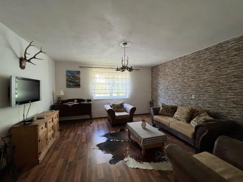 a living room with a couch and a brick wall at Dedinky Lakeview Cottage in Dedinky