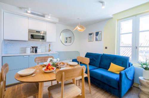 a living room with a blue couch and a table at Résidence Feniers - Hyper centre St Tropez in Saint-Tropez