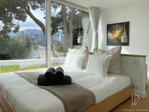a bedroom with a large bed with a large window at Villa Velas in La Herradura