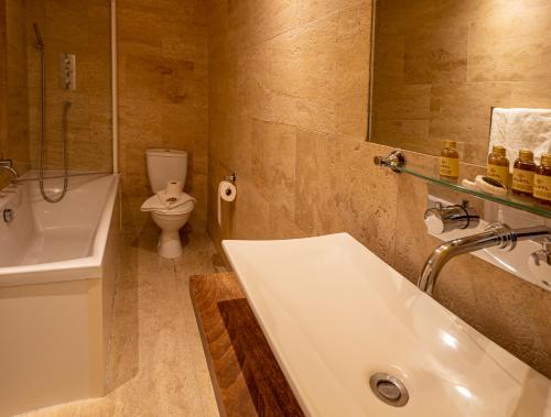 a bathroom with a tub and a sink and a toilet at The Bulkeley Hotel in Beaumaris