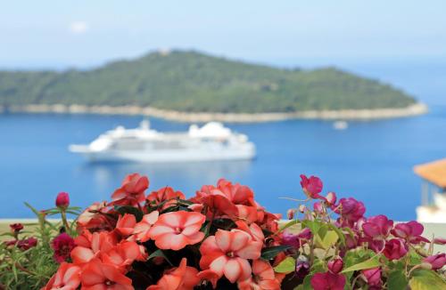 um pote de flores com um barco na água em Blue Harmony Sea View Apartment em Dubrovnik