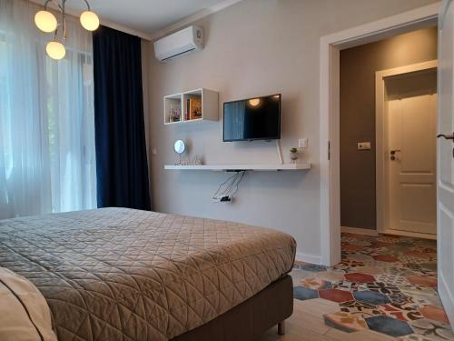 a bedroom with a bed and a tv on the wall at Tara Deluxe Apartment in Varna City