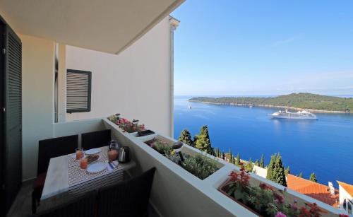 ドゥブロヴニクにあるBlue Harmony Sea View Apartmentの水辺の景色を望むバルコニー(テーブル付)
