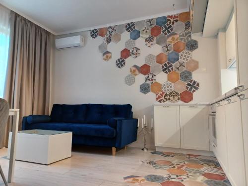 a living room with a blue couch and a kitchen at Tara Deluxe Apartment in Varna City