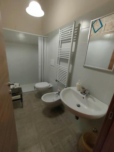 a white bathroom with a sink and a toilet at Dimora delle Badesse in Conversano
