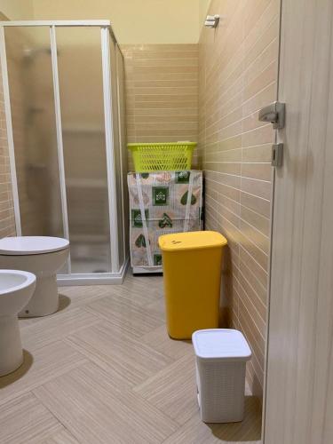 - une salle de bains avec 2 toilettes et une poubelle jaune dans l'établissement Casa Monica, à Torre Vado