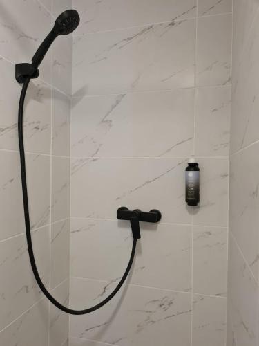 a shower with a black shower head on a wall at Mojo Resort in Eforie Sud