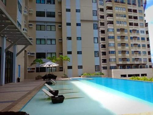 uma piscina em frente a um grande edifício em Free WI-FI and Pool Persimmon Condominium em Cebu