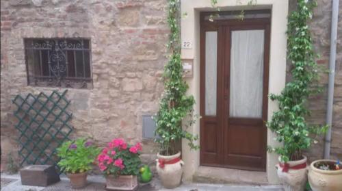 eine Tür eines Gebäudes mit Topfpflanzen davor in der Unterkunft Casa Contadina in borgo medievale, Tuscany in Monteguidi