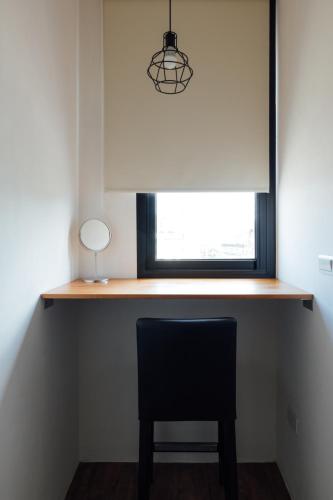a desk with a chair in front of a window at 5963 Turn Right B&B in Jiaoxi