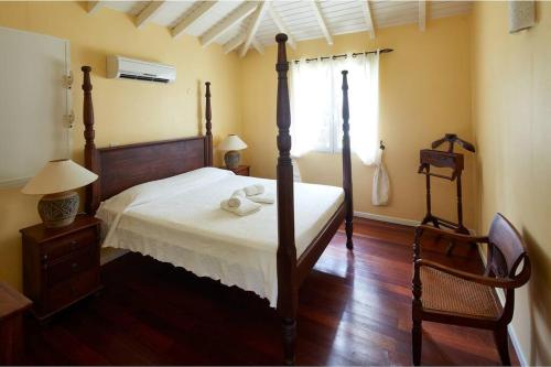 a bedroom with a four poster bed and a window at Villa Gauguin in Sainte-Rose