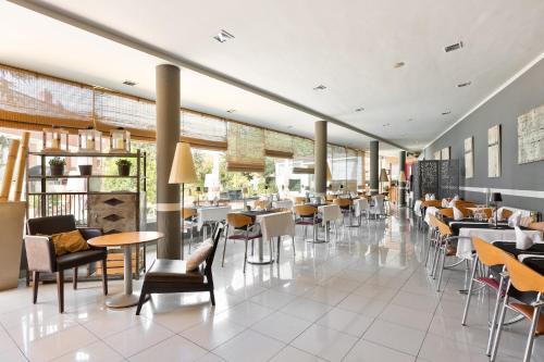 a restaurant with tables and chairs in a building at PARK SEDO Aparthotel in Rub&iacute;