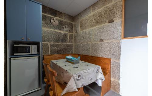 a small kitchen with a table and a refrigerator at Beautiful Apartment In A Arnoia in Arnoia