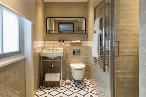 W łazience znajduje się umywalka, toaleta i lustro. w obiekcie 55 by Le Mirage w Londynie