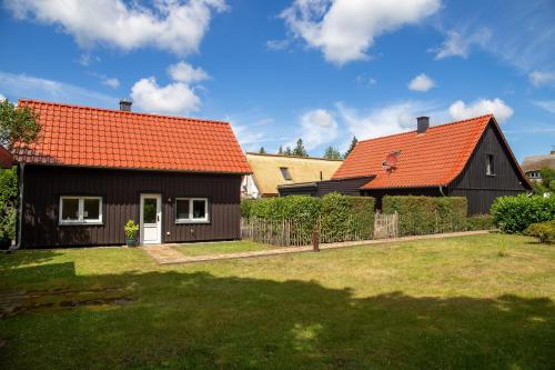 a black house with an orange roof at Sonnenwieck 01 in Wieck