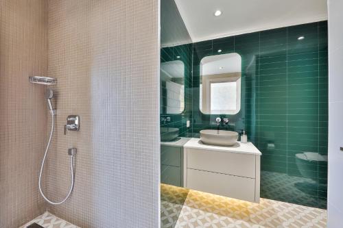 a bathroom with a sink and a shower with green tiles at Peninsula Gardens Hotel in Kas